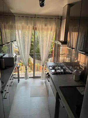a kitchen with a large glass door to a balcony at Nice vauban in Nice