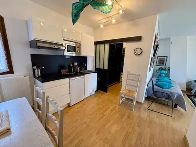 a kitchen and living room with a table and chairs at Havre de paix proche de Nice in Aspremont