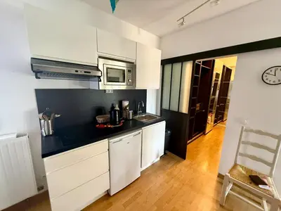 a kitchen with white cabinets and a microwave at Havre de paix proche de Nice in Aspremont