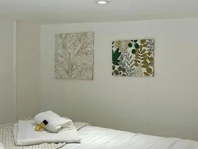 a bedroom with two paintings on the wall and a bed at Studio Dore Fshh in Nice