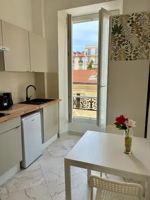 a kitchen with a table and a large window at Studio Dore Fshh in Nice