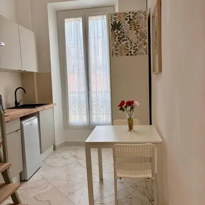 a kitchen with a table and a vase of flowers on it at Studio Dore Fshh in Nice