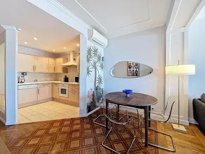 a kitchen and living room with a table and chairs at Nestor&Jeeves - PROMENADE DU SUD - Vue Mer in Nice
