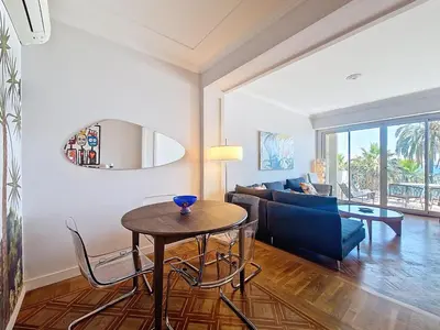 a living room with a table and a couch at Nestor&Jeeves - PROMENADE DU SUD - Vue Mer in Nice