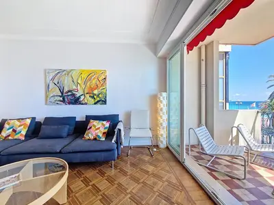 a living room with a couch and a table and chairs at Nestor&Jeeves - PROMENADE DU SUD - Vue Mer in Nice