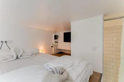 a bedroom with two white beds and a flat screen tv at Etudiants port - 1pers, wifi, AC in Nice