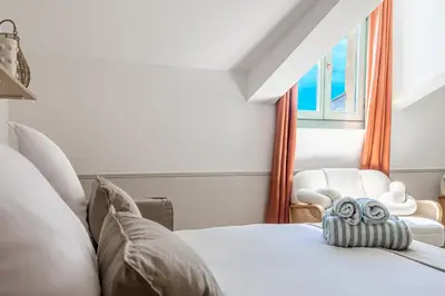 a bedroom with a bed and a chair and a window at Exceptional location, 2BR right on Place Massena, Newly Renovated in Nice
