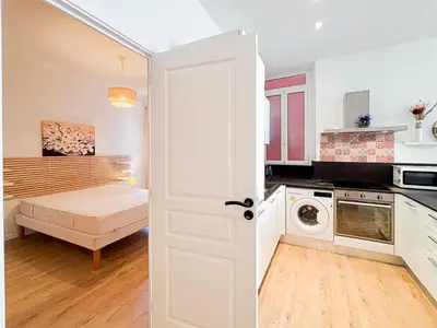 a kitchen with white cabinets and a black counter top at Stalingrad - Wifi, AC, 4pers in Nice