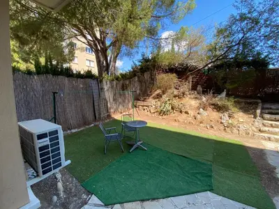 a small yard with a table and chairs on the grass at Nice hillside with 100 sqm private garden in Nice