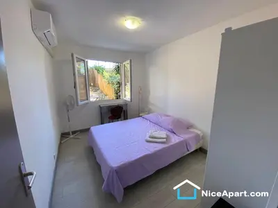 a small bedroom with a bed and a window at Nice hillside with 100 sqm private garden in Nice