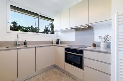 a kitchen with white cabinets and a window at Quiet & Open View - 1 Bdr Large Terrace in Nice