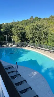 a large swimming pool with lounge chairs and trees at Mobil home Oasi in Cagnes-sur-Mer