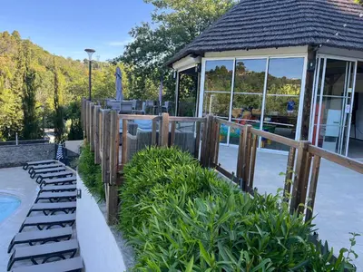 a wooden fence with benches next to a pool at Mobil home Oasi in Cagnes-sur-Mer
