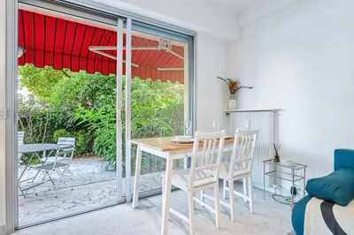 a dining room with a table and chairs and a window at Studio Mimosas - Welkeys in Cagnes-sur-Mer