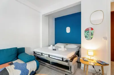 a small bedroom with a bed and a couch at Studio Mimosas - Welkeys in Cagnes-sur-Mer