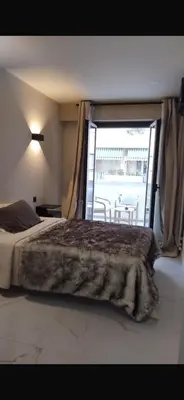 a bedroom with a bed and a large window at Nice in Nice