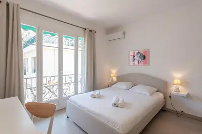 a bedroom with a white bed and a large window at L4 Fayad 2BDR Hotel des Postes Central, Massena AC 2Balconies in Nice