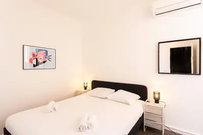 a bedroom with a white bed with two white pillows at L4 Fayad 2BDR Hotel des Postes Central, Massena AC 2Balconies in Nice