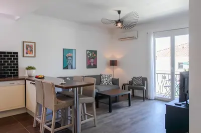 a kitchen and living room with a table and chairs at L4 Fayad 2BDR Hotel des Postes Central, Massena AC 2Balconies in Nice
