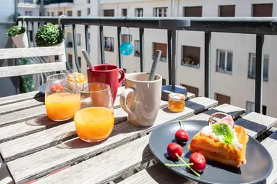 a table with a plate of food and glasses of orange juice at L4 Fayad 2BDR Hotel des Postes Central, Massena AC 2Balconies in Nice