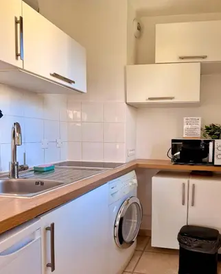 a kitchen with a washing machine and a sink at Studio près mer et aéroport - Studio near sea and airport in Nice