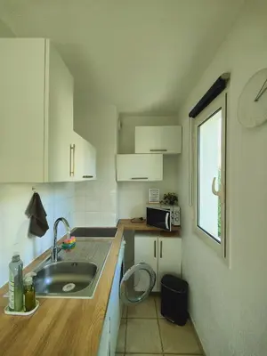 a kitchen with a sink and a clock on the wall at Studio près mer et aéroport - Studio near sea and airport in Nice