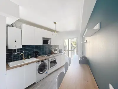 a kitchen with a table and a washing machine at Beautiful 4 rooms sea airport in Nice