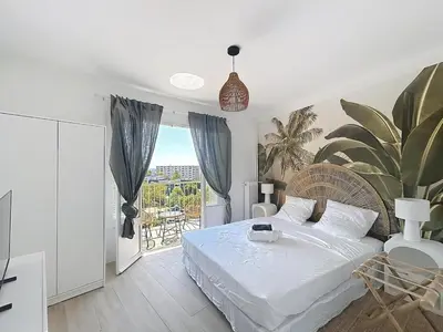 a white bedroom with a bed and a balcony at Beautiful 4 rooms sea airport in Nice