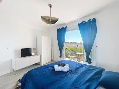 a bedroom with a blue bed and a large window at Beautiful 4 rooms sea airport in Nice