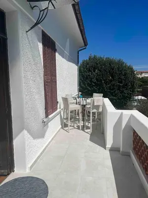 a patio with a table and chairs on a house at Appartement spacieux proche mer idéalement situé in Cagnes-sur-Mer