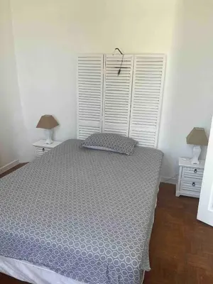 a bedroom with a large bed and two night stands at Appartement spacieux proche mer idéalement situé in Cagnes-sur-Mer
