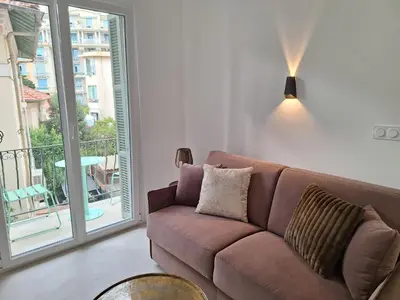 a brown couch in a living room with a balcony at Arty & Chic à Nice in Nice