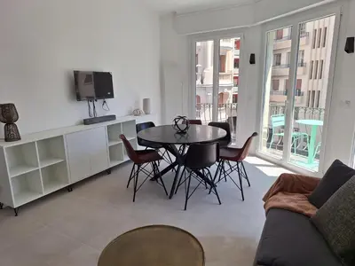 a living room with a table and a tv at Iconic and bright style in Nice in Nice