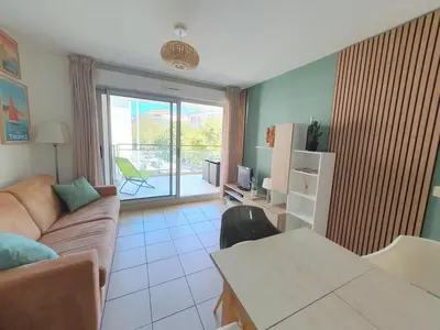 a living room with a couch and a table at 2P pour 4 personnes grande terrasse avec lit parapluie piscine sur le toit et parking en sous-sol in Cagnes-sur-Mer