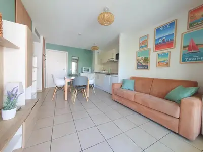 a kitchen with a table and chairs in a kitchen at 2P pour 4 personnes grande terrasse avec lit parapluie piscine sur le toit et parking en sous-sol in Cagnes-sur-Mer