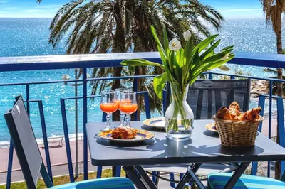 a table with plates of food and glasses of orange juice at Amazing Sunset in Nice