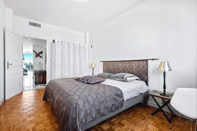 a bedroom with a bed and a table and a chair at Amazing Sunset in Nice