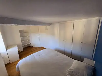 a bedroom with a white bed and white cabinets at Plaisirs entre mer et montagne in Aspremont