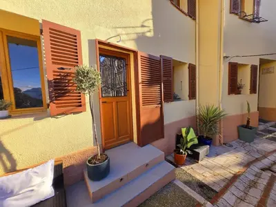 a house with potted plants in front of a door at Plaisirs entre mer et montagne in Aspremont