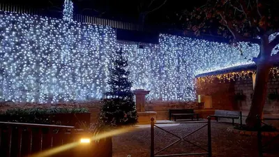a christmas tree in front of a large screen with lights at Plaisirs entre mer et montagne in Aspremont