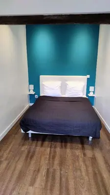 a bed in a room with a blue wall at 17 Cassini in Nice
