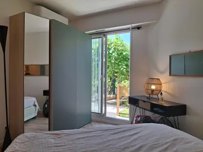 a bedroom with a bed and a desk and a window at Lovely apartment with private garden and a swimming-pool in Nice