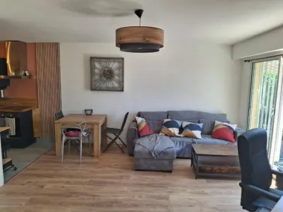 a living room with a couch and a table at Lovely apartment with private garden and a swimming-pool in Nice