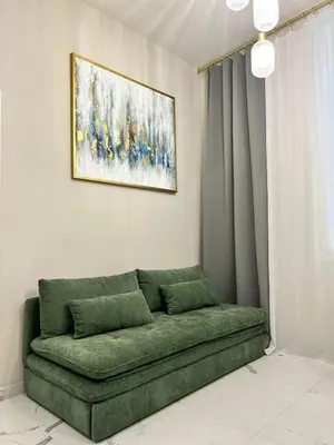 a green couch in a room with a painting on the wall at Pearl of Nice in Nice