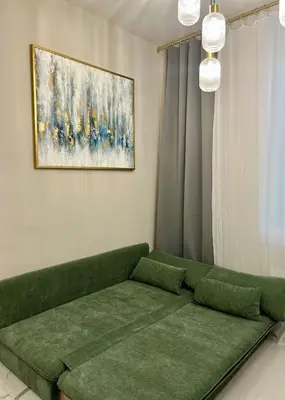 a green couch in a living room with a painting at Pearl of Nice in Nice