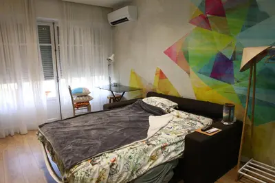 a bedroom with a bed and a colorful wall at Modern Appart Nice, proche Gare Riquier in Nice
