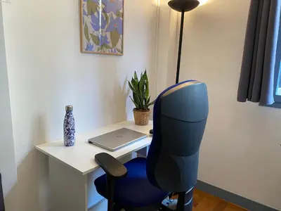 a blue chair sitting next to a desk with a laptop at Easy and accessible beach flat near the university in Nice
