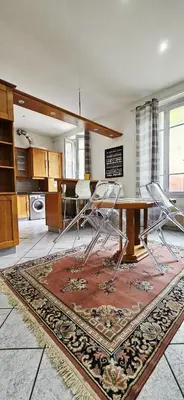 a kitchen with a table and chairs on a rug at Spacious apartment in Cimiez in Nice