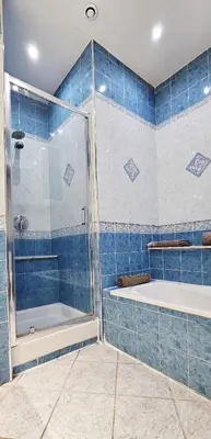 a blue tiled bathroom with a tub and a shower at Spacious apartment in Cimiez in Nice