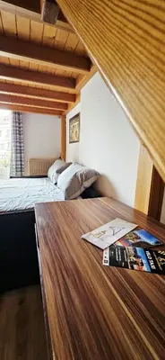 a bedroom with two beds and a wooden table at Spacious apartment in Cimiez in Nice